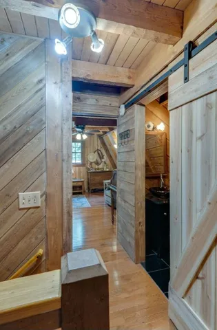 a view of a hallway with wooden floor fireplace and living room