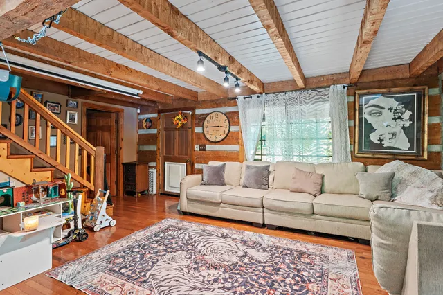 a living room with furniture a rug and a large window