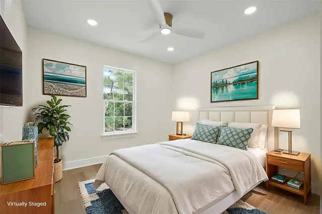 a bedroom with a large bed and a potted plant