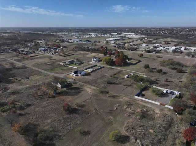 a view of a dry yard with trees