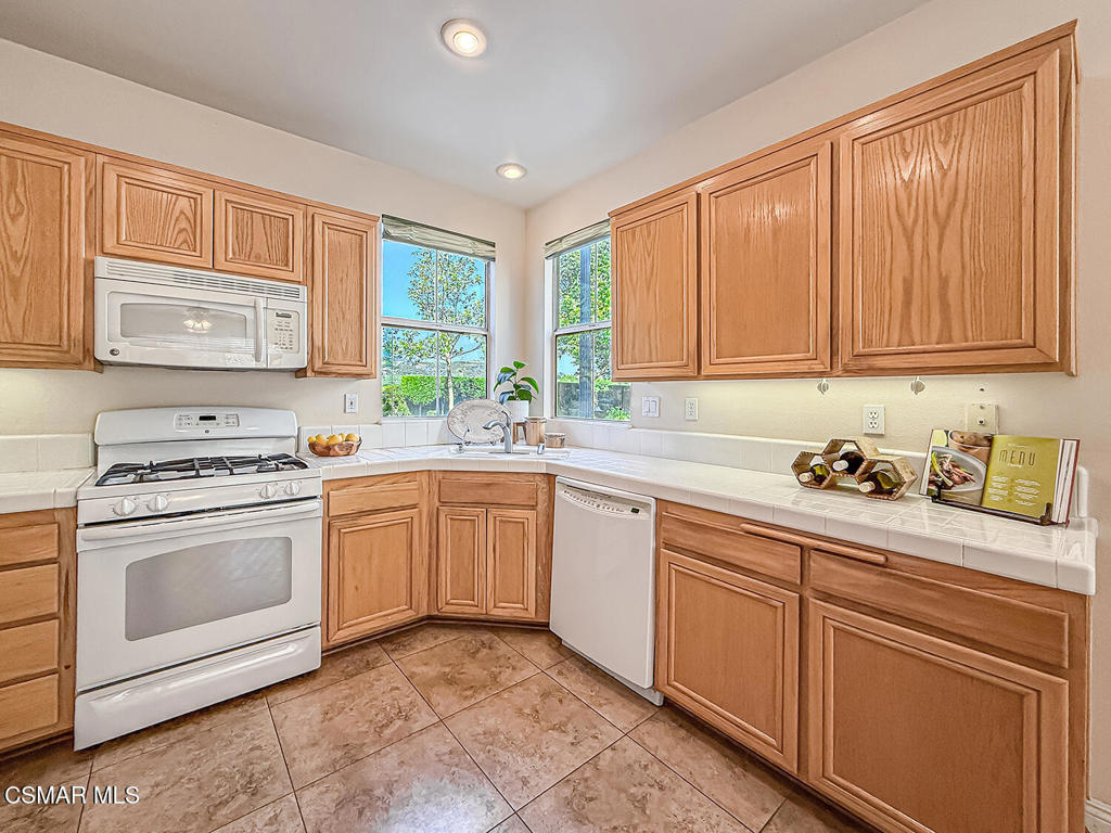 4030 Villamonte Court Camarillo, CA 93010 - Photo 13 of 42 a kitchen with granite countertop white cabinets sink and white appliances