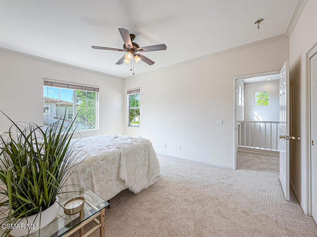 4030 Villamonte Court Camarillo, CA 93010 - Photo 28 of 42 a spacious bedroom with a balcony a bed and a chandelier