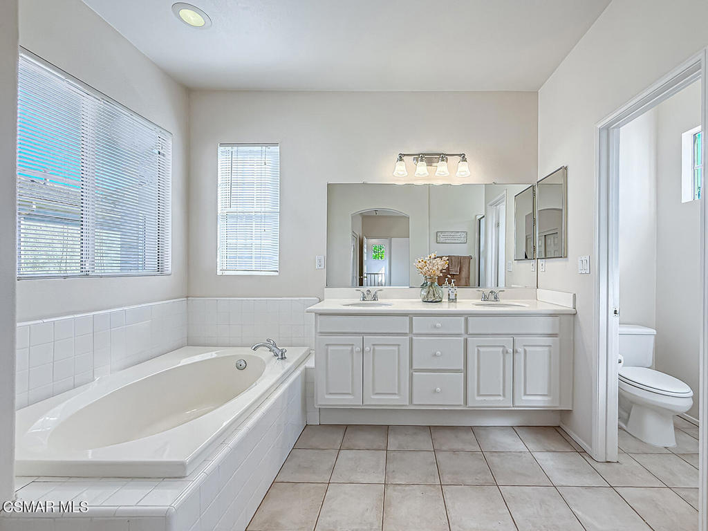 4030 Villamonte Court Camarillo, CA 93010 - Photo 29 of 42 a spacious bathroom with a granite countertop sink a toilet mirror and bathtub