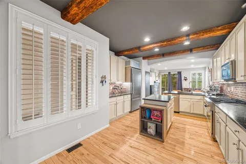 a kitchen with stainless steel appliances granite countertop a stove and a wooden floors