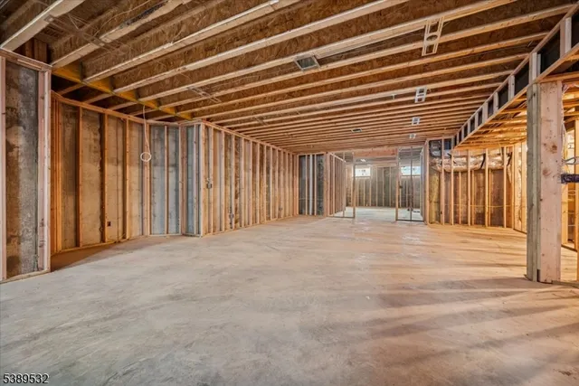 a view of a white house next to a yard with large trees