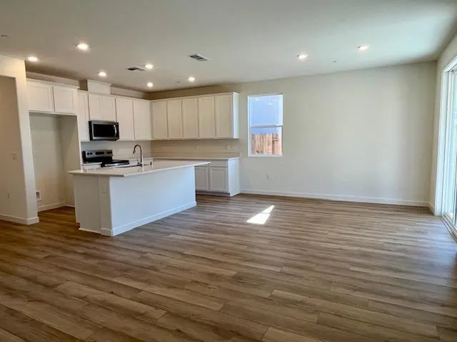 a kitchen with granite countertop a stove and a wooden floor
