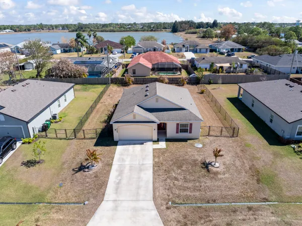 an aerial view of a house with yard swimming pool and ocean view