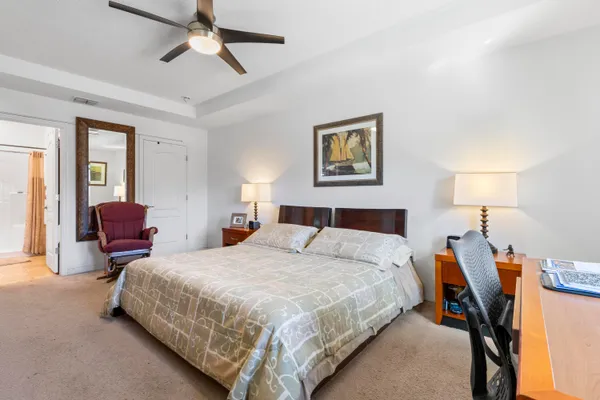 a bedroom with a bed a chandelier and dresser