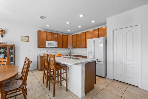 a kitchen with stainless steel appliances granite countertop a stove a refrigerator a microwave oven with white cabinets and island