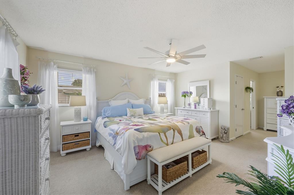 12577 Southwest Kings Row Lake Suzy, FL 34269 - Photo 15 of 56 a bedroom with a bed a chandelier and a window