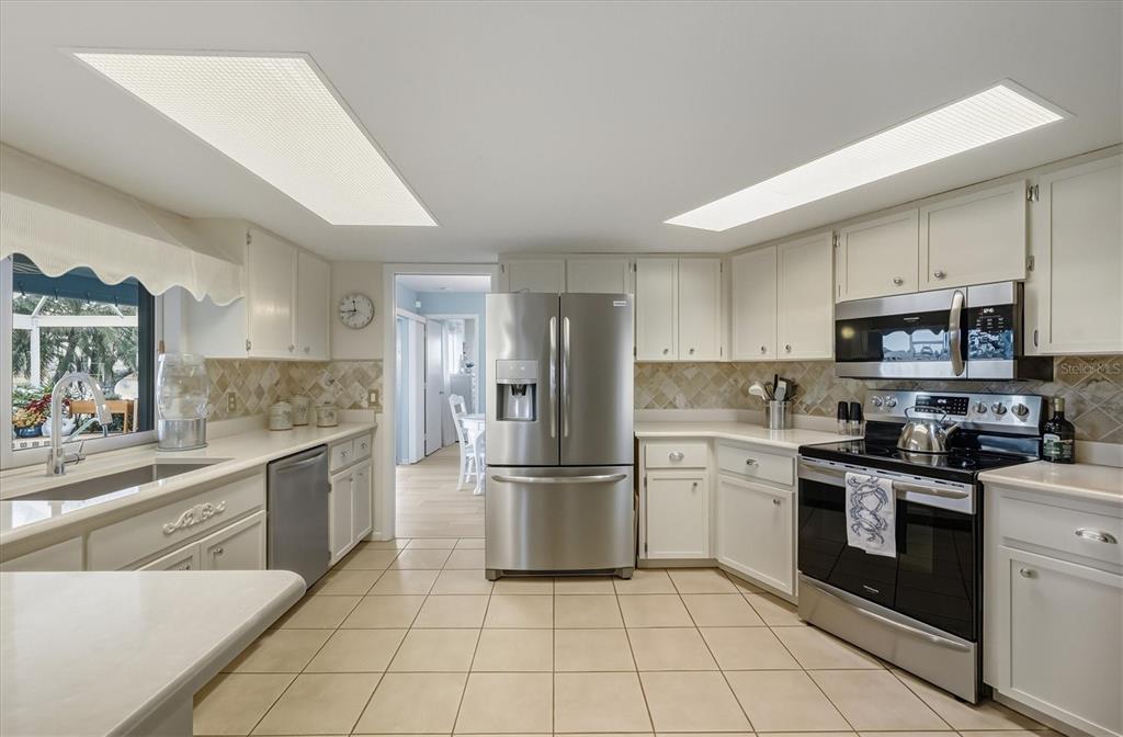 12577 Southwest Kings Row Lake Suzy, FL 34269 - Photo 19 of 56 a kitchen with stainless steel appliances granite countertop a refrigerator and a stove top oven