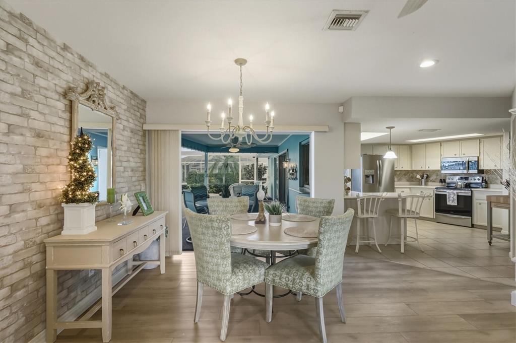 12577 Southwest Kings Row Lake Suzy, FL 34269 - Photo 23 of 56 a view of a dining room with furniture and chandelier