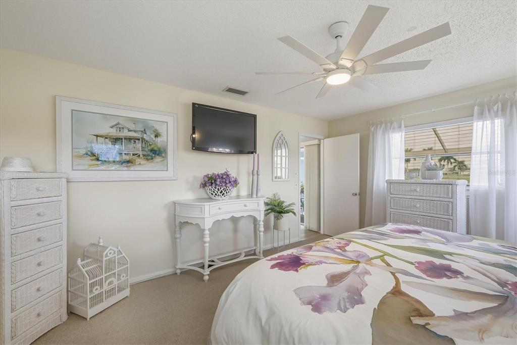 12577 Southwest Kings Row Lake Suzy, FL 34269 - Photo 26 of 56 a bedroom with a large bed and a flat tv screen on dresser