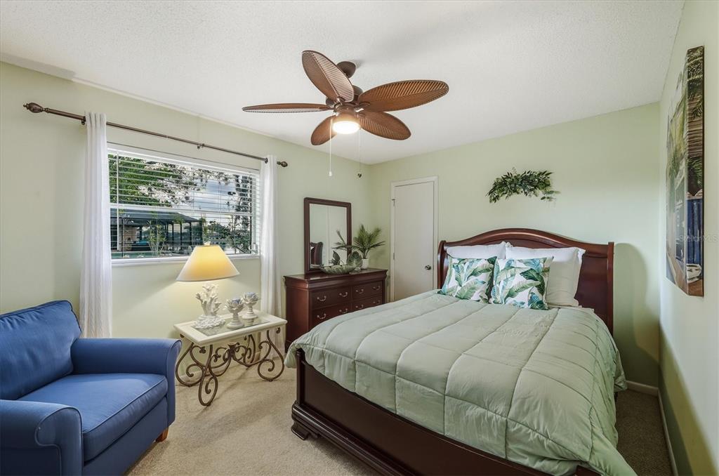 12577 Southwest Kings Row Lake Suzy, FL 34269 - Photo 28 of 56 a spacious bedroom with a bed couch and window