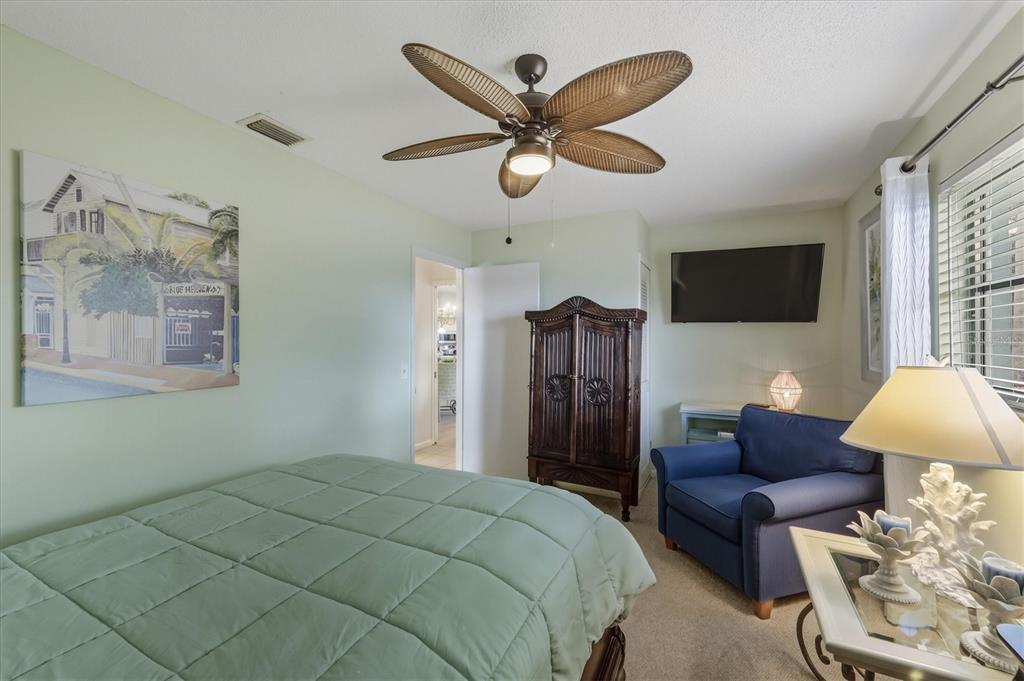 12577 Southwest Kings Row Lake Suzy, FL 34269 - Photo 29 of 56 a bed room with a bed and a ceiling fan