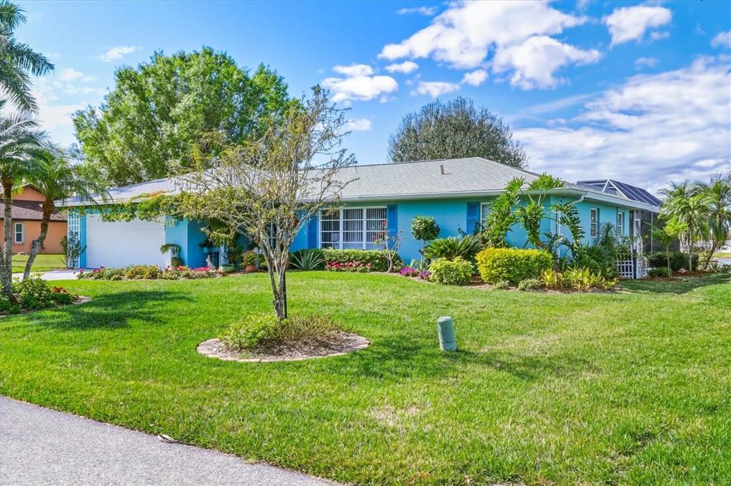 12577 Southwest Kings Row Lake Suzy, FL 34269 - Photo 5 of 56 a front view of a house with a yard garden and fountain