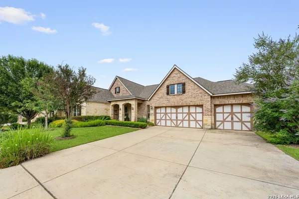 a front view of a house with a yard and trees