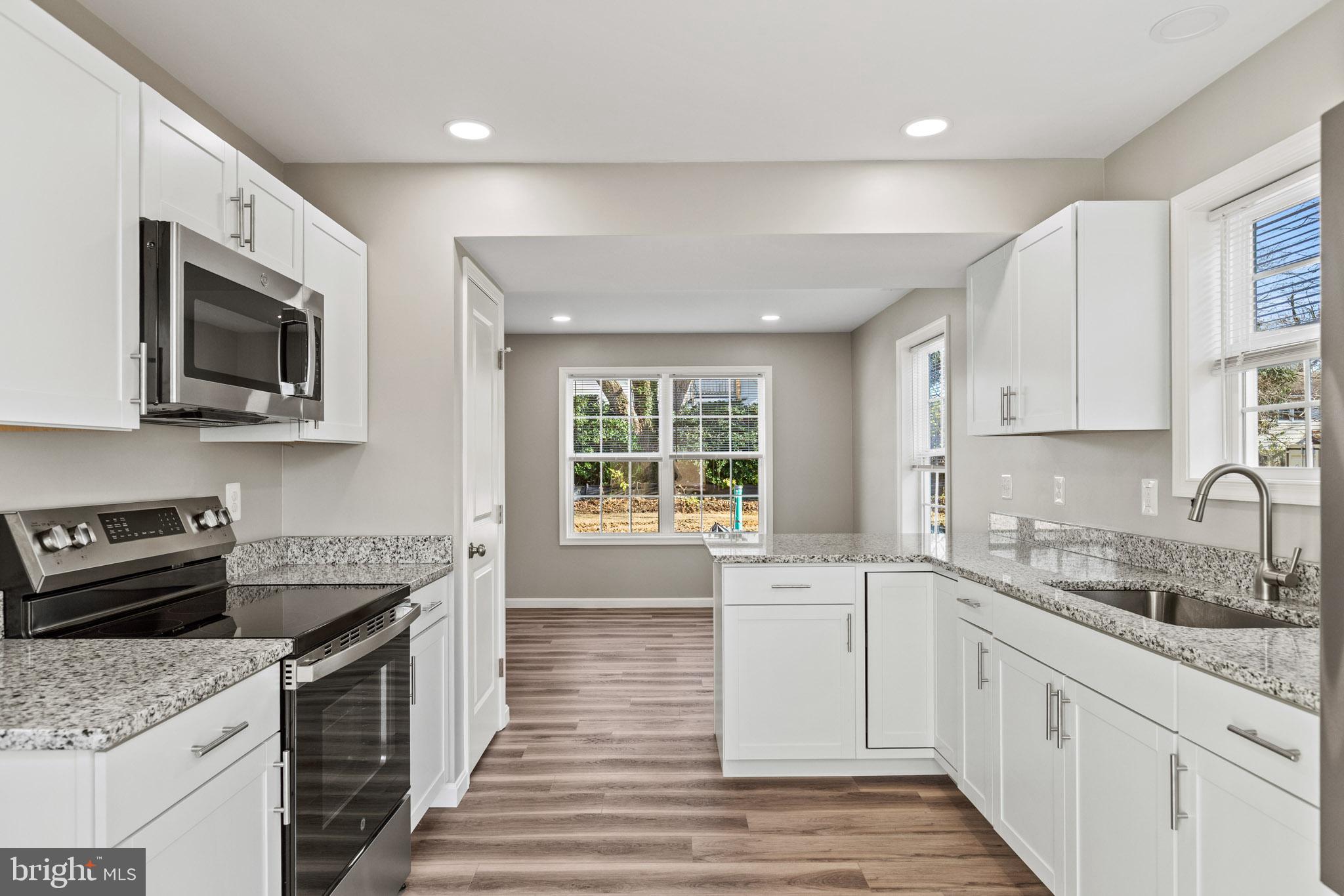 a kitchen with a sink stove top oven and refrigerator