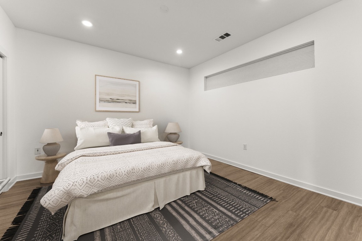 4361 South Congress Avenue, Unit 514 Austin, TX 78745 - Photo 16 of 28 a spacious bedroom with a bed and wooden floor