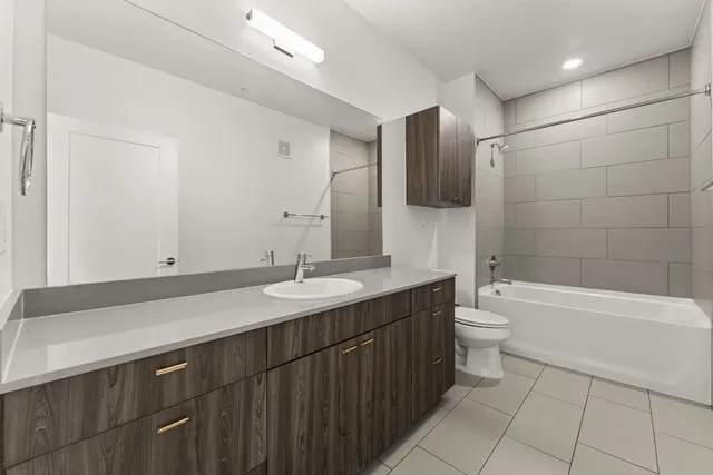 a bathroom with a granite countertop sink a toilet and bathtub