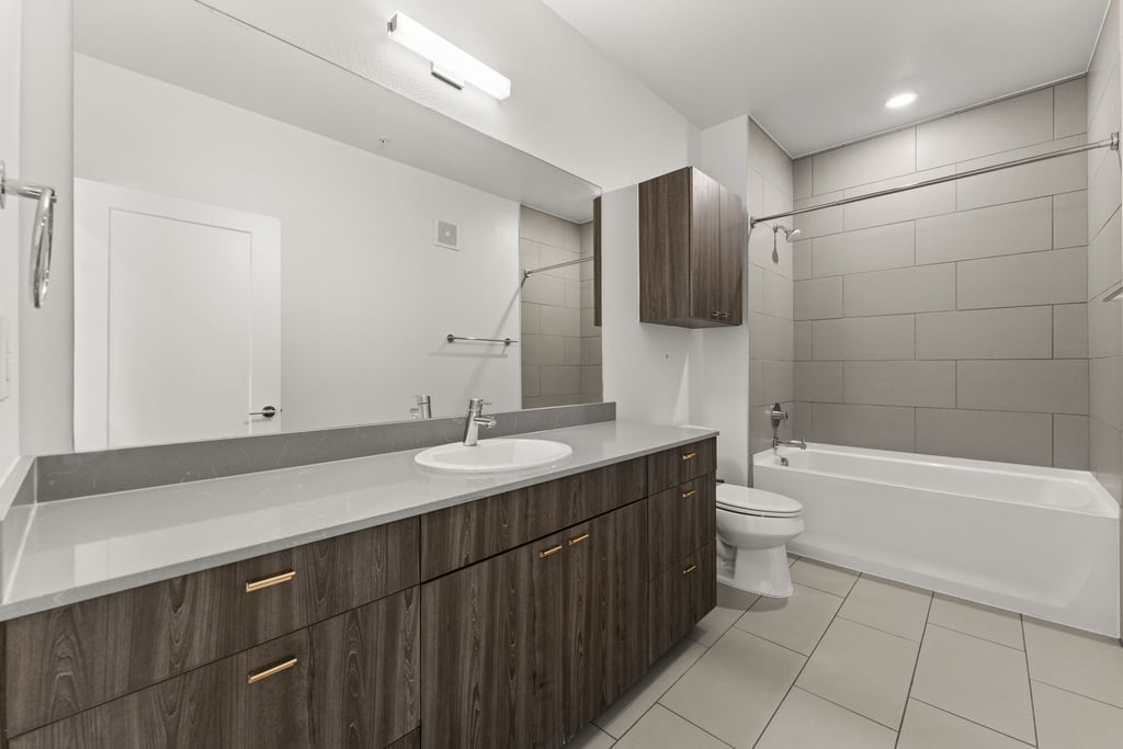 4361 South Congress Avenue, Unit 514 Austin, TX 78745 - Photo 18 of 28 a bathroom with a granite countertop sink a toilet and bathtub