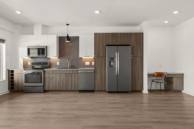 a kitchen with stainless steel appliances a refrigerator and a stove top oven