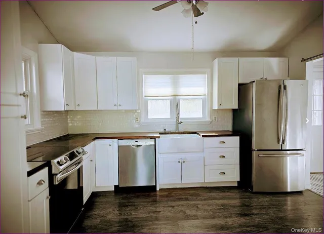 a kitchen with granite countertop a refrigerator and a sink