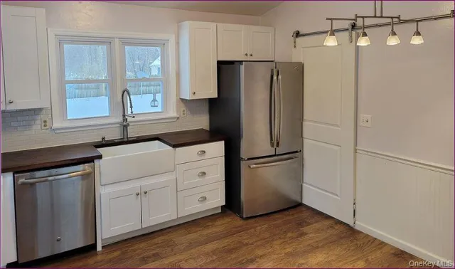 a kitchen with appliances a refrigerator and a sink