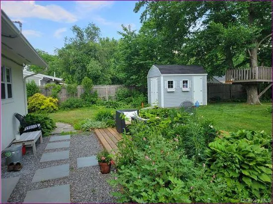 a view of balcony with wooden fence and large trees