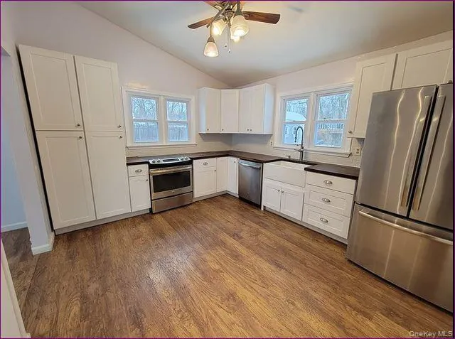 a kitchen with granite countertop a refrigerator a sink a stove a microwave and island