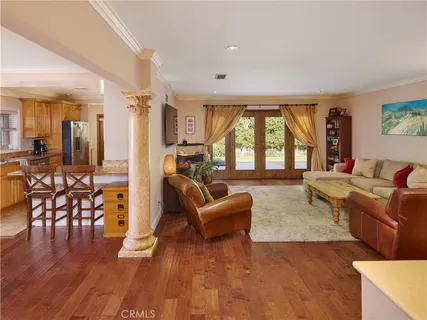 a living room with furniture wooden floor and a large window