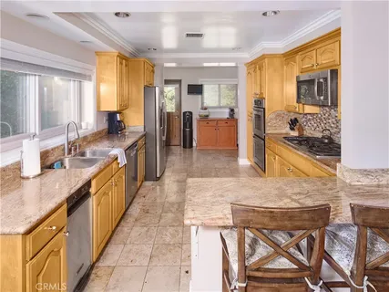 a large kitchen with kitchen island granite countertop wooden cabinets and a stove