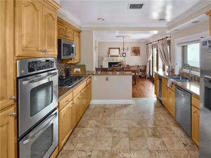 a large kitchen with a stove top oven a sink a counter space and cabinets