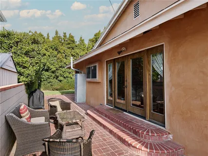 a view of a patio with table and chairs with wooden floor and fence