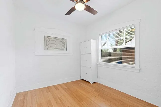a view of an empty room with a window and a ceiling fan