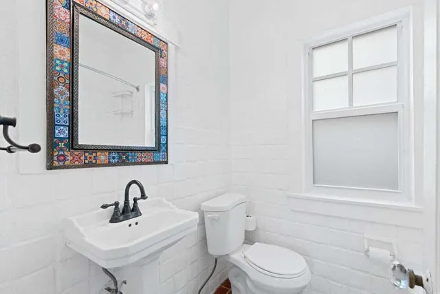 a bathroom with a toilet a sink and mirror