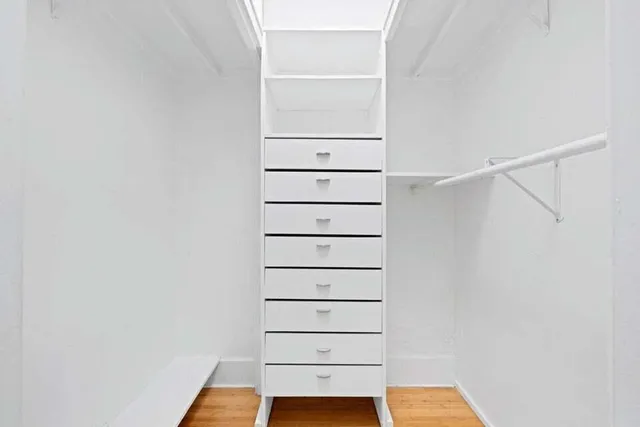 a view of walk in closet with empty racks