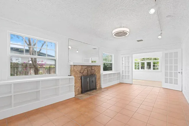 a view of empty room with a fireplace and large window
