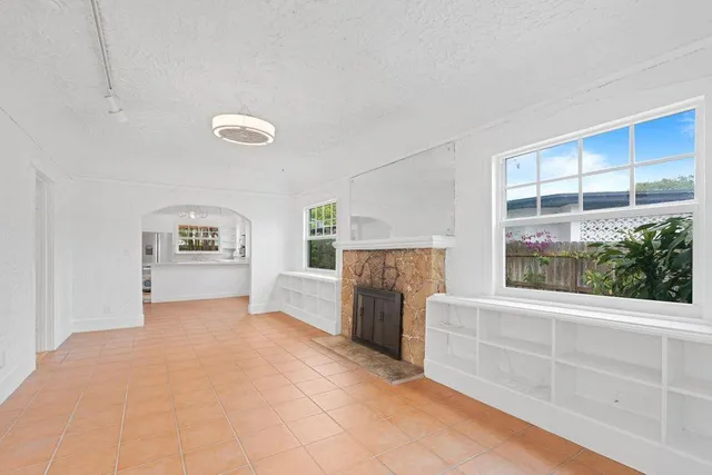 a view of an empty room with a fireplace and a window