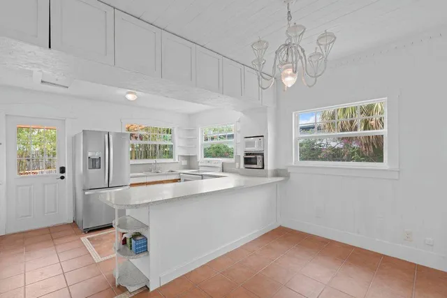 a kitchen with stainless steel appliances granite countertop a sink window and cabinets