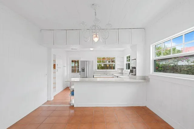 a view of a kitchen with kitchen island a stove a sink and a window