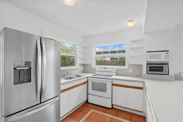 a kitchen that has a sink stainless steel appliances and cabinets