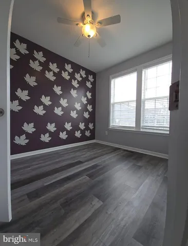 a view of empty room with window and chandelier fan