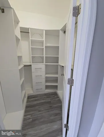 a view of walk in closet with empty racks