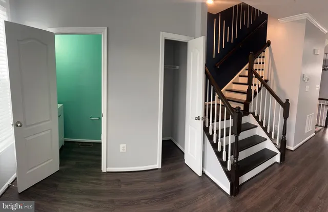 a view of a hallway with wooden floor and stairs