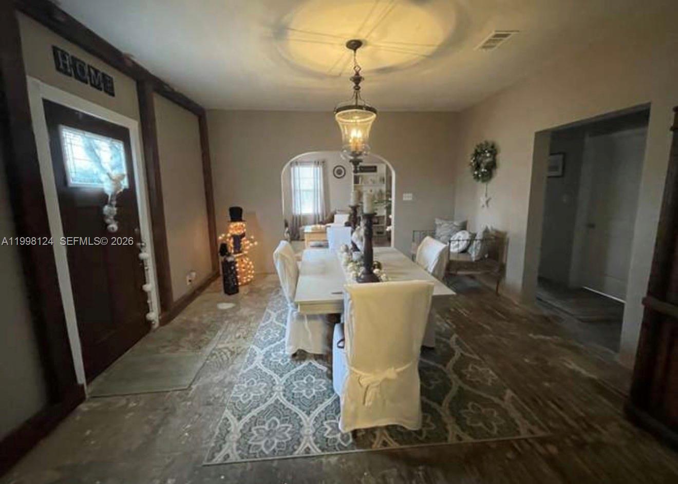 1005 Lakewood Road Pensacola, FL 32507 - Photo 16 of 23 a dining room with wooden floor a chandelier a wooden table and chairs