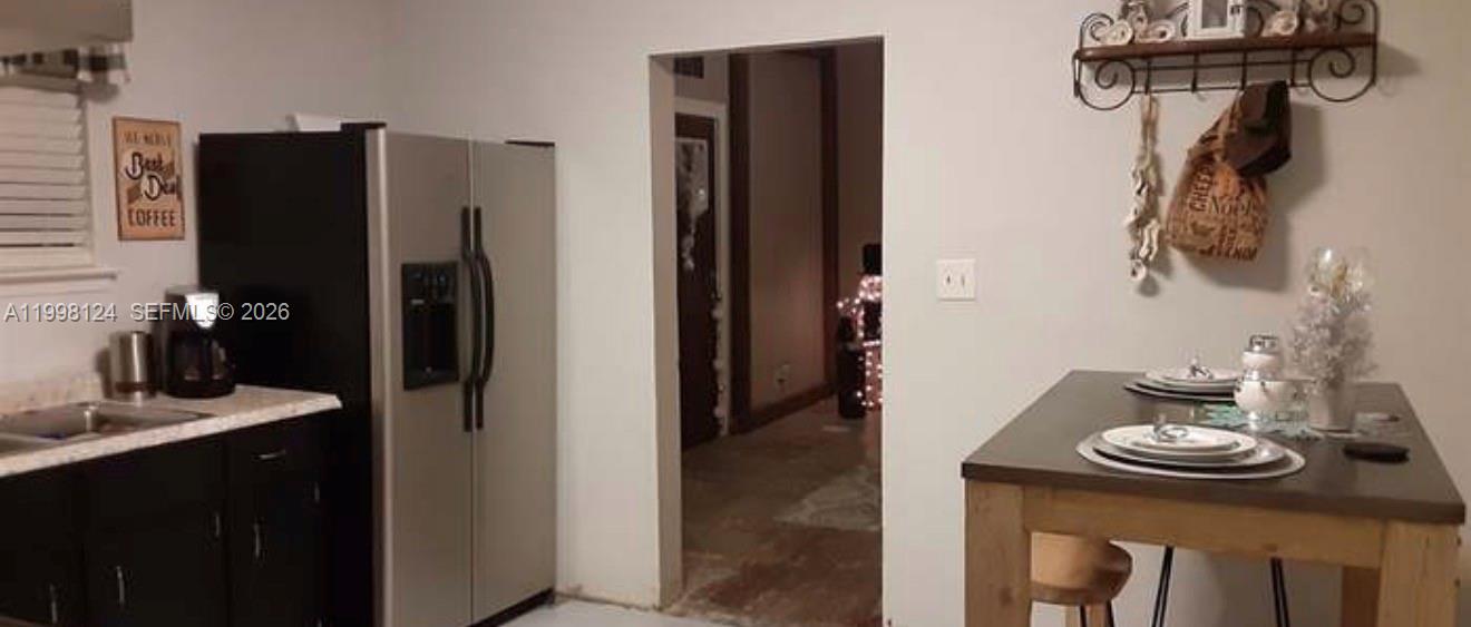 1005 Lakewood Road Pensacola, FL 32507 - Photo 3 of 23 a kitchen with a refrigerator and dining table
