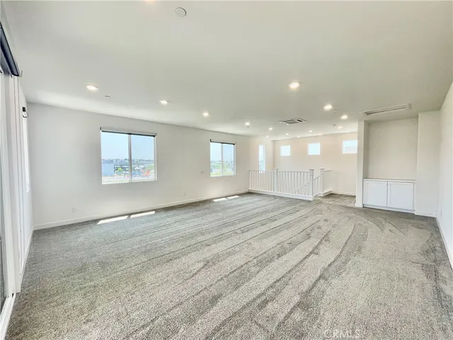 a view of empty room with kitchen and window