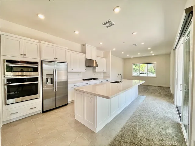 a large kitchen with a large counter top stainless steel appliances and cabinets