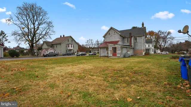 a view of a house with a big yard and large trees